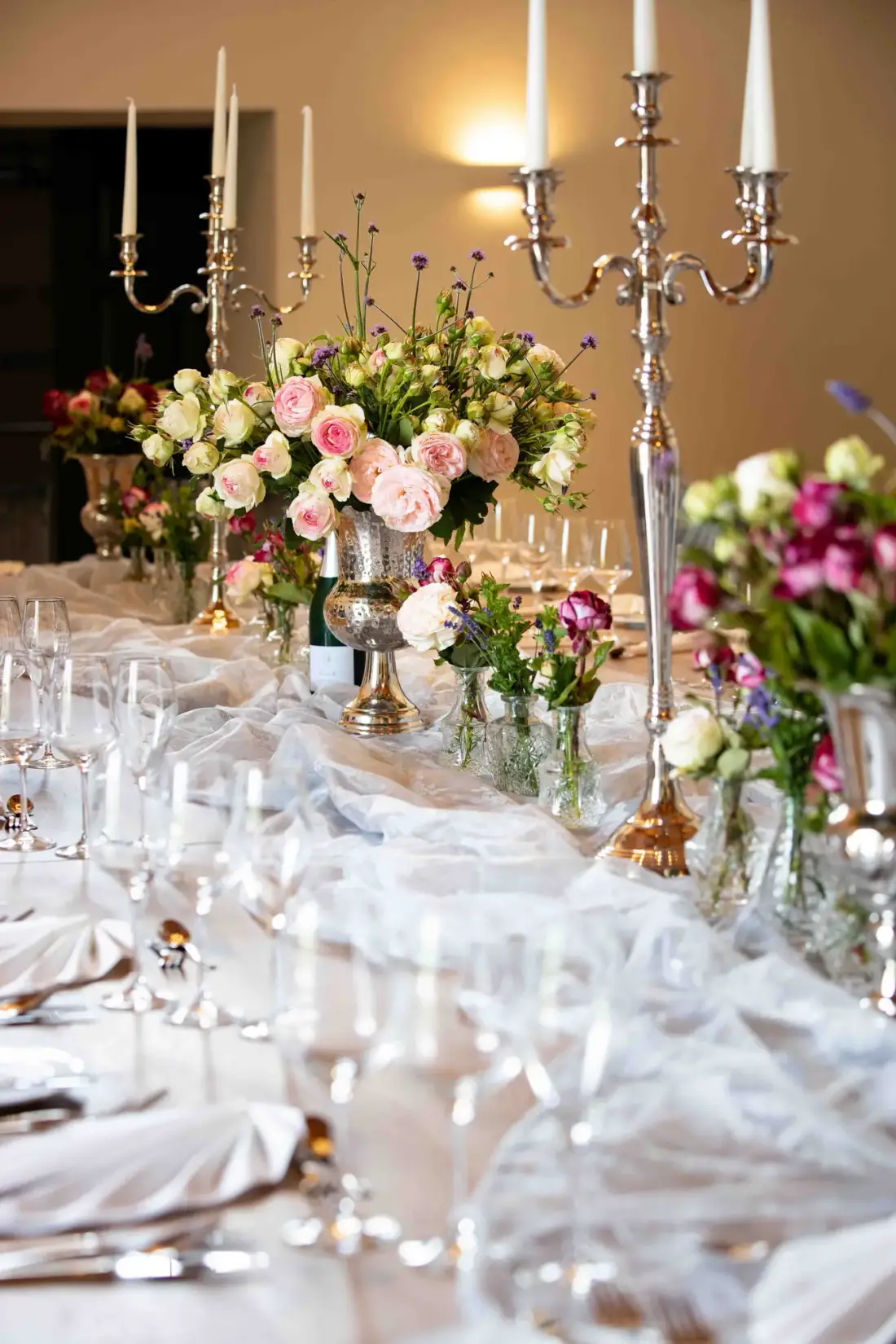 Festlich gedeckte Hochzeitstafel mit Kerzenleuchtern und Blumen